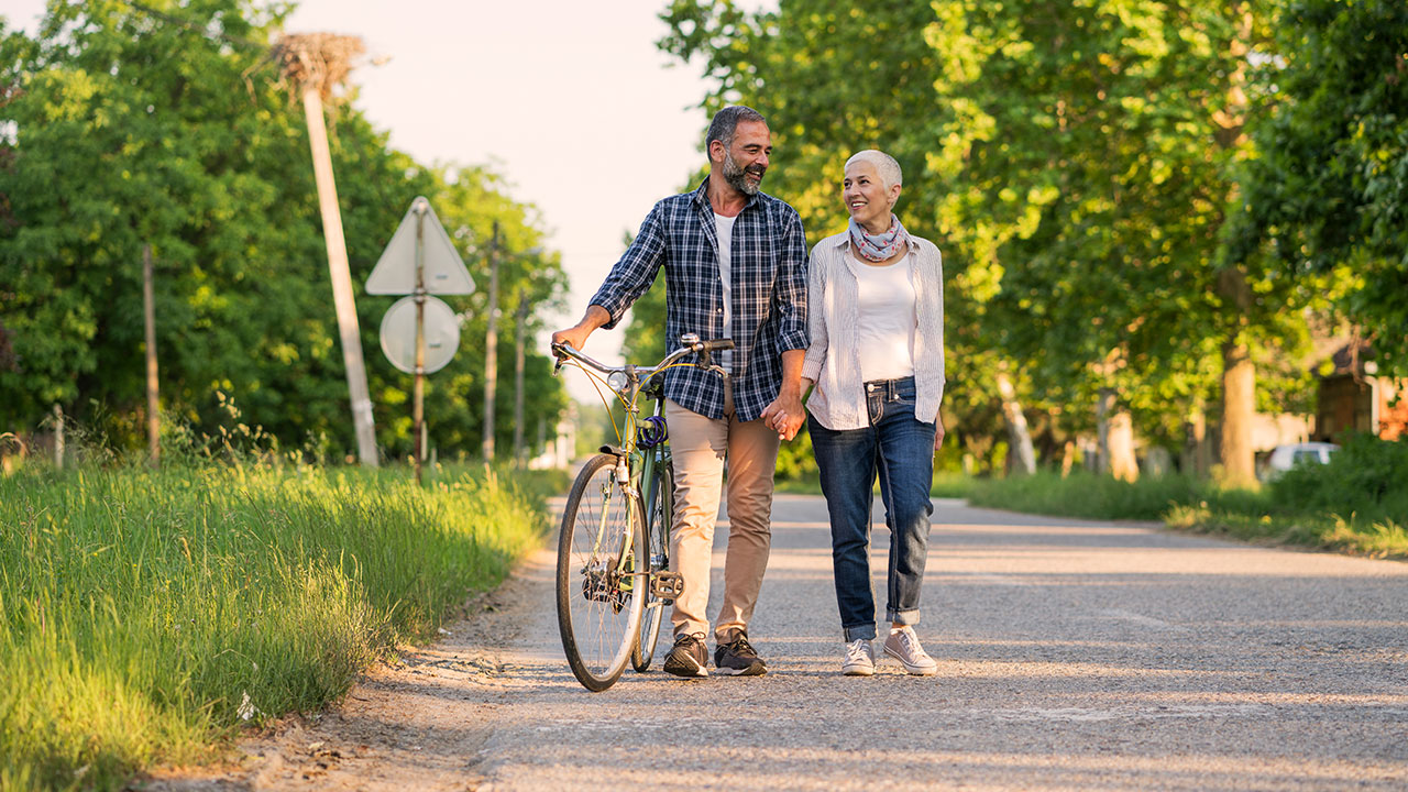 retired couple walking with bike